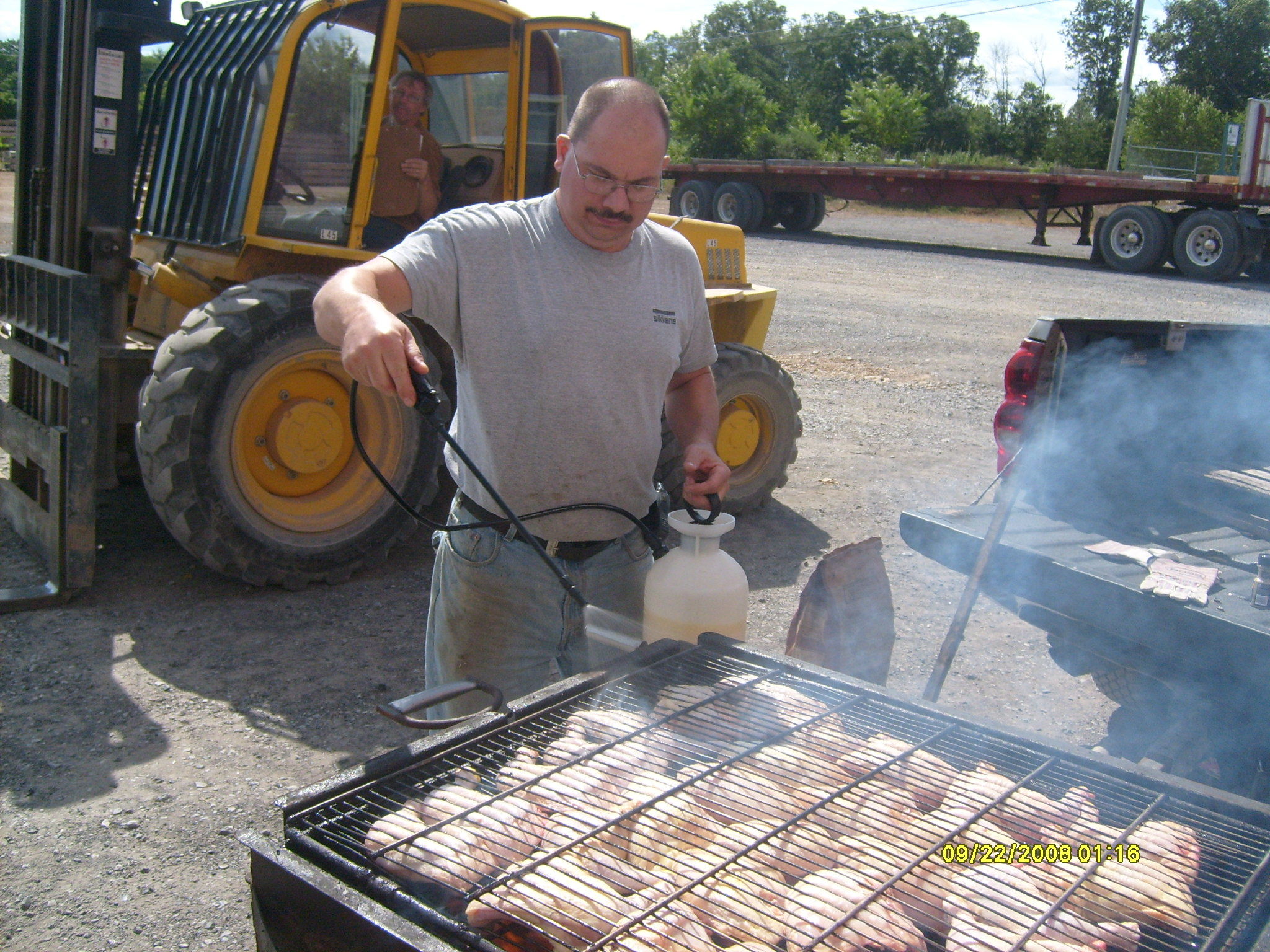 Randy grilling BBQ chicken on nice summer day, employee spotlight, Randy Beachel, Timberhaven Log Homes, log homes, log cabin homes, log cabins, post and beam homes, timberframe homes, timber frame homes, laminated logs, engineered logs, floor plan designs, kiln dried logs