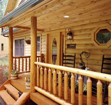 Log Home Porch with Rustic Rail Treatment Illustrates the Use of Natural Building Components in Log Home Construction
