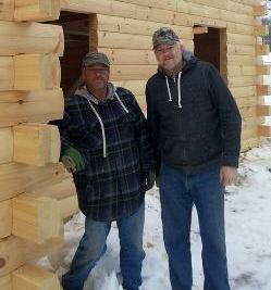 two guys standing by a log home, built in the winter, winter build, building a log home in the winter, Timberhaven, log homes, timber frame homes, under construction