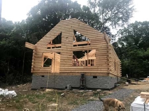 log home being built, solid gables, log walls, new model log home under construction