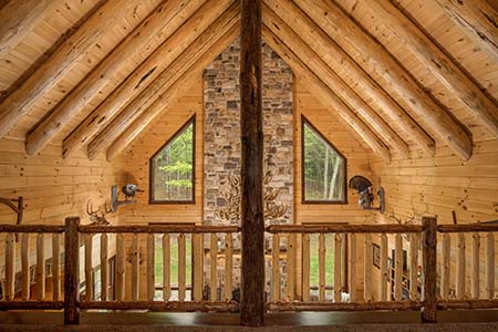 Round rafters in log home loft.