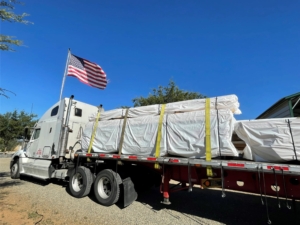 materials package on tractor trailer truck, under construction, Timberhaven, comparing log and timber home estimates